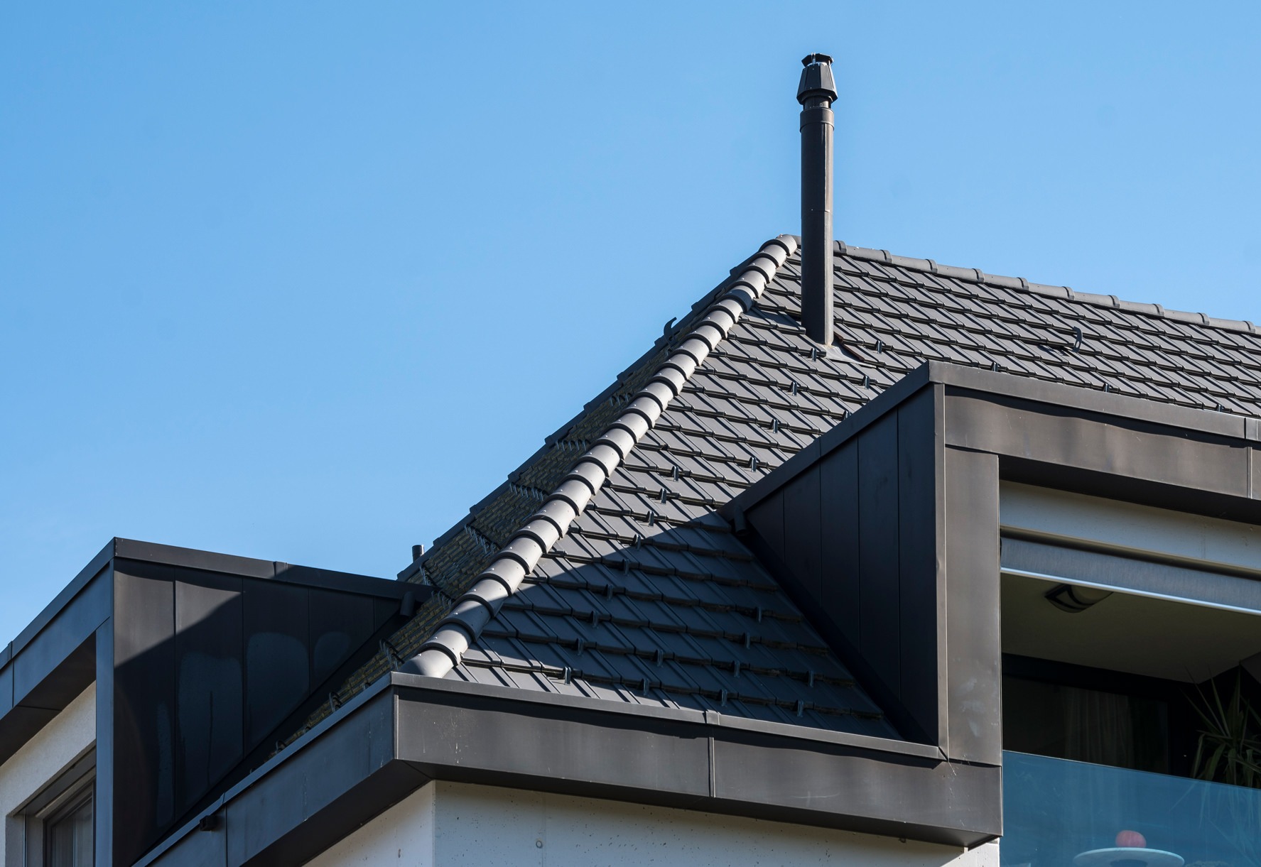 Aussenansicht einer Wohnüberbauung in Kiesen in Bern, deren Dächer mit Flachschiebeziegeln von Gasser Ceramic eingedeckt sind.
