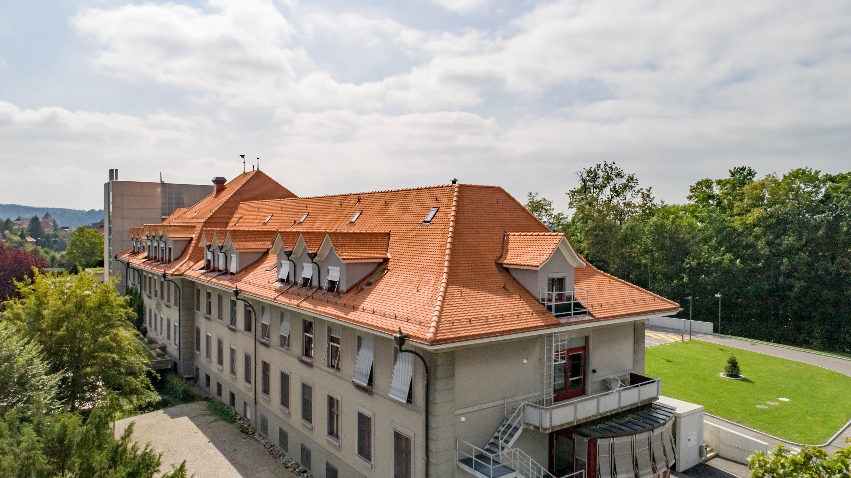 Neues Dach des Spitals Aarberg, eingedeckt mit Berner Biberschwanzziegeln in naturrot von Gasser Ceramic