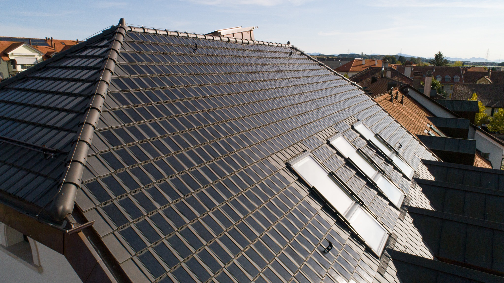 Raiffeisen Gros de Vaud, Echallens, eingedeckt mit Photovoltaik PAN 32 Dachziegeln von Gasser Ceramic, Aussenaufnahme